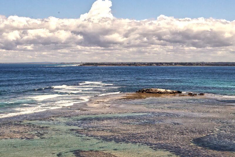 Portsea where harbour meets the Pacific ocean lighthouse in distance