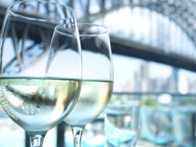 Wine glasses in a restaurant with Sydney Harbour Bridge in the background, Australia