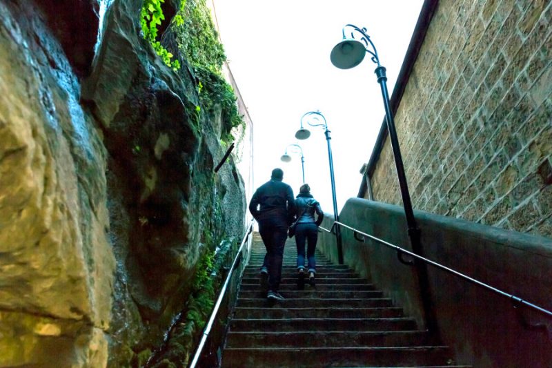 Young couple walking on the old steps of Gloucester Walk in The Rocks Sydney, Australia