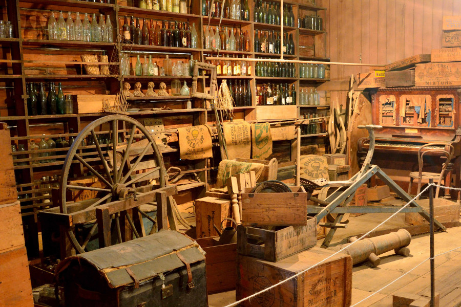 Interior view of Brennan and Geraghty Store museum in Maryborough, QLD, with old furniture, shelves of bottles and tins, boxes and cases, Queensland, Australia