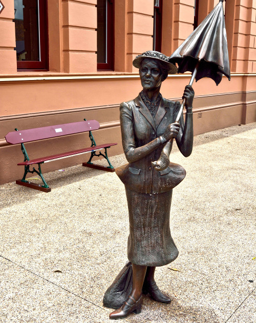Life-size bronze statue of umbrella-wielding Mary Poppins on the corner of Richmond and Wharf streets in Maryborough, QLD
